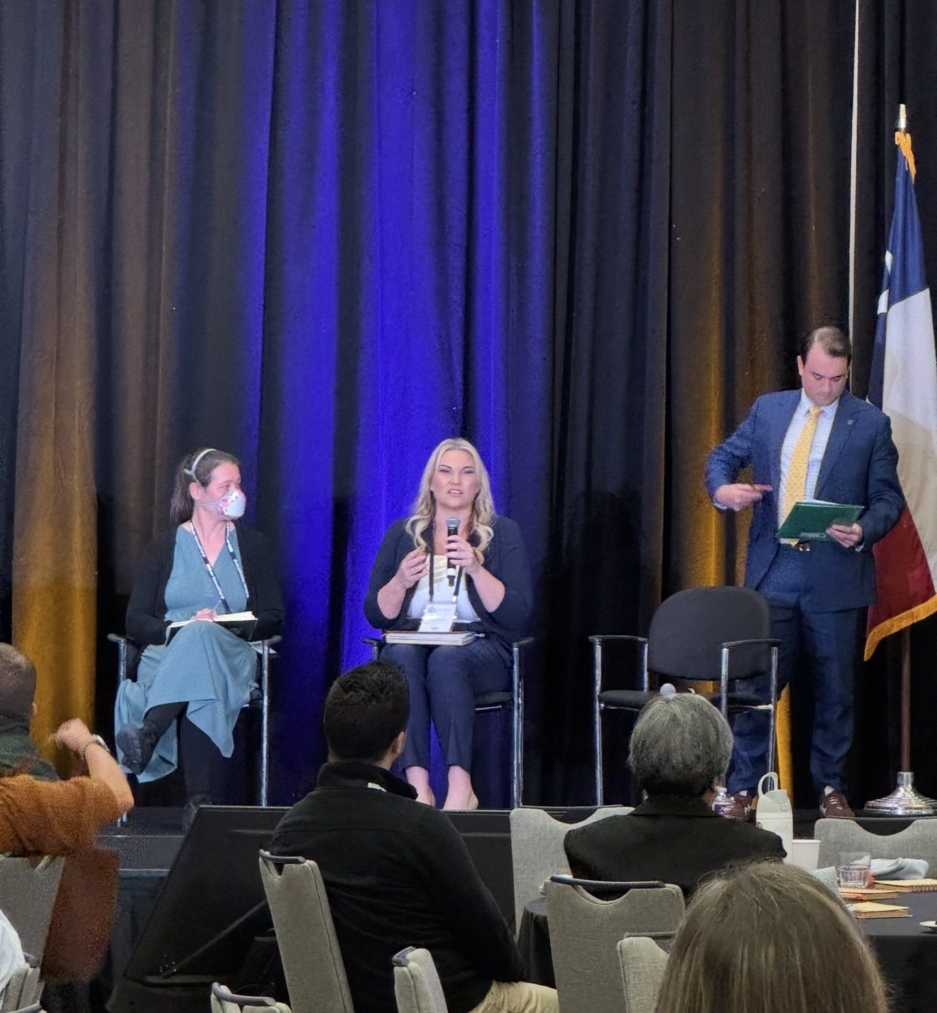 Michelle Robertson speaking with a microphone on a transit conference panel in front of an audience